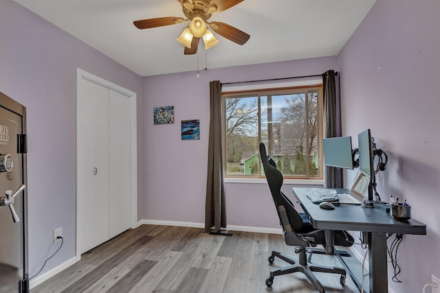 home office with baseboards, light wood-style flooring, and ceiling fan