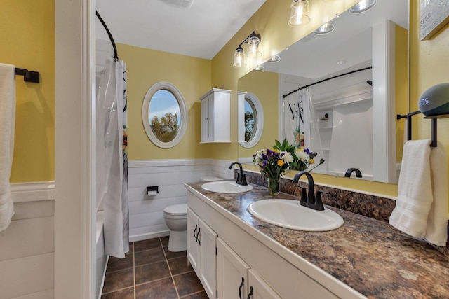 full bathroom featuring tile patterned flooring, a sink, double vanity, and toilet