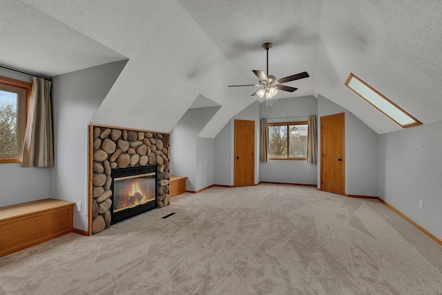 bonus room with carpet floors, a ceiling fan, a textured ceiling, and vaulted ceiling with skylight