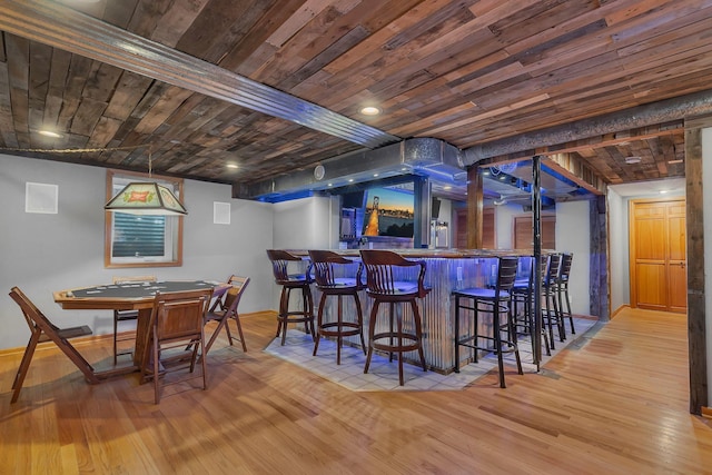 bar featuring wooden ceiling, bar area, wood-type flooring, and baseboards