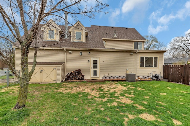 rear view of property with a yard, central AC unit, a fenced backyard, and roof with shingles