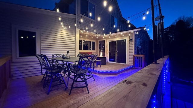 deck at twilight featuring outdoor dining space