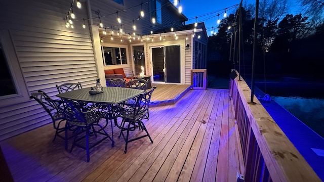 deck at twilight with outdoor dining area