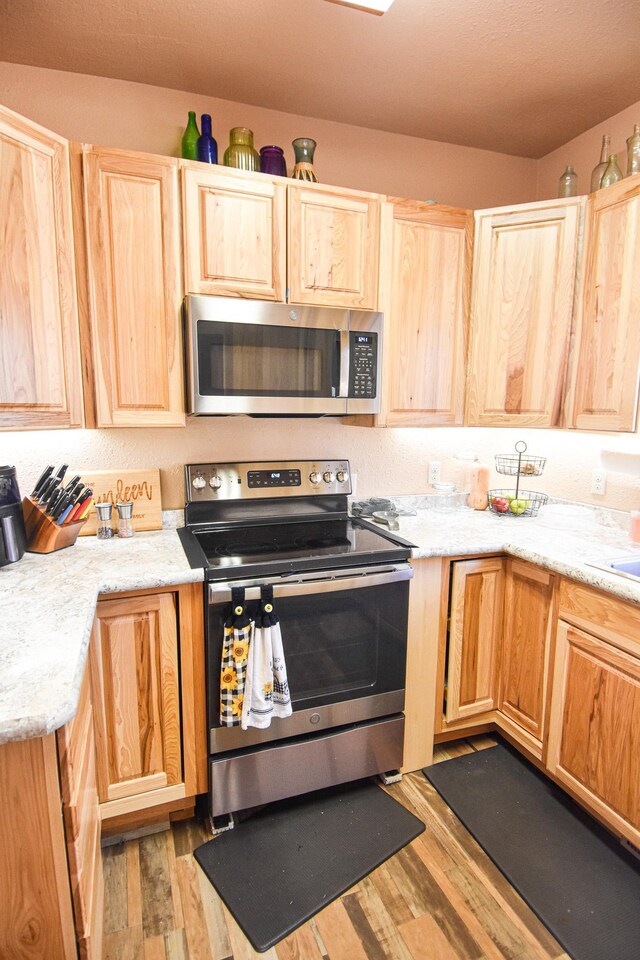 11287 135th Ave NE, Thief River Falls, MN 56701 - kitchen with appliances with stainless steel finishes, wood finished floors, and light brown cabinetry