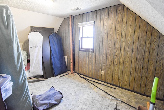 11287 135th Ave NE, Thief River Falls, MN 56701 - additional living space featuring a textured ceiling, wood walls, lofted ceiling, and visible vents