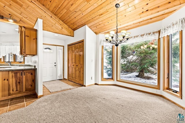 kitchen featuring brown cabinets, a chandelier, vaulted ceiling, and a healthy amount of sunlight