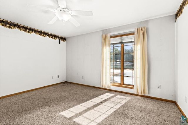 spare room featuring carpet flooring, baseboards, and a ceiling fan