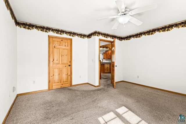 carpeted spare room with baseboards and ceiling fan