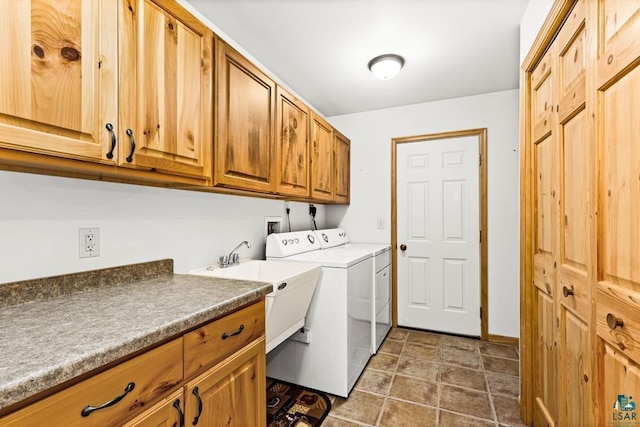 washroom featuring cabinet space, washer and dryer, and a sink