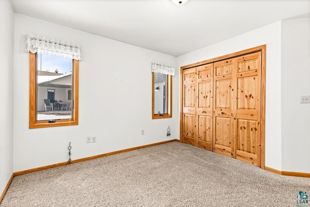 unfurnished bedroom with carpet flooring and baseboards