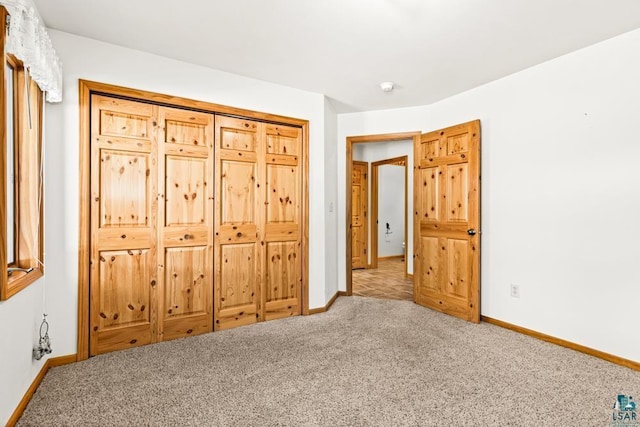 unfurnished bedroom with carpet floors and baseboards