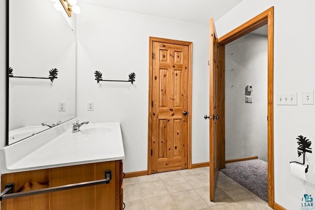bathroom with vanity, baseboards, and tile patterned flooring