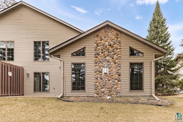 rear view of house featuring a lawn