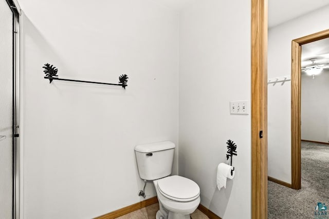 bathroom featuring baseboards and toilet