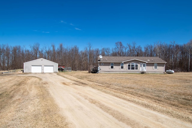 23665 One Mile Rd NE, Blackduck, MN 56630 - view of front facade with a garage, a front lawn, driveway, an outbuilding, and a wooded view