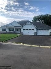 view of front of property featuring an attached garage and aphalt driveway