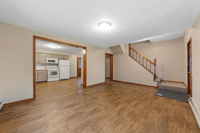 unfurnished living room with stairs, a baseboard radiator, baseboards, and wood finished floors