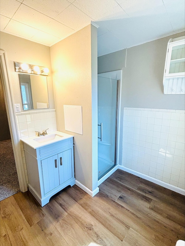full bath featuring backsplash, a shower stall, wood finished floors, and vanity