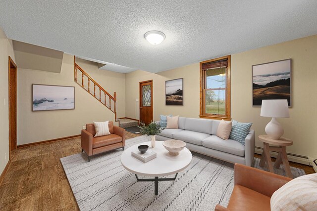 36530 251st Ave, Le Center, MN 56057 - living room with wood finished floors, a textured ceiling, stairway, baseboards, and a baseboard radiator