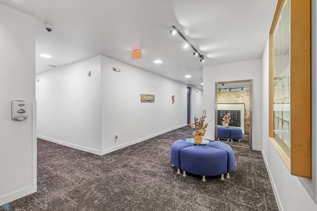 interior space featuring carpet, baseboards, and track lighting