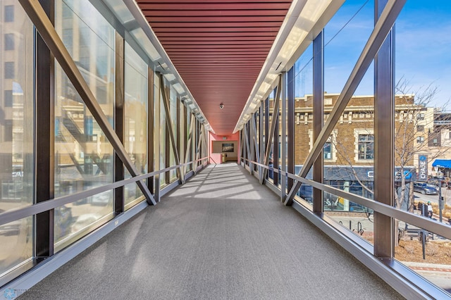 corridor featuring wooden ceiling and floor to ceiling windows
