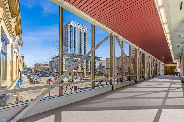 exterior space with floor to ceiling windows, a view of city, carpet, and plenty of natural light