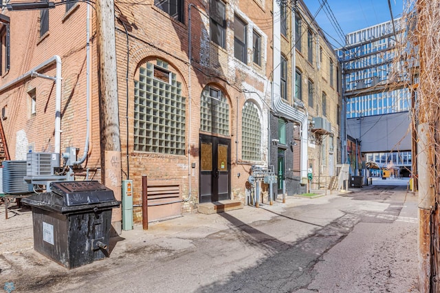 exterior space with brick siding and central AC unit