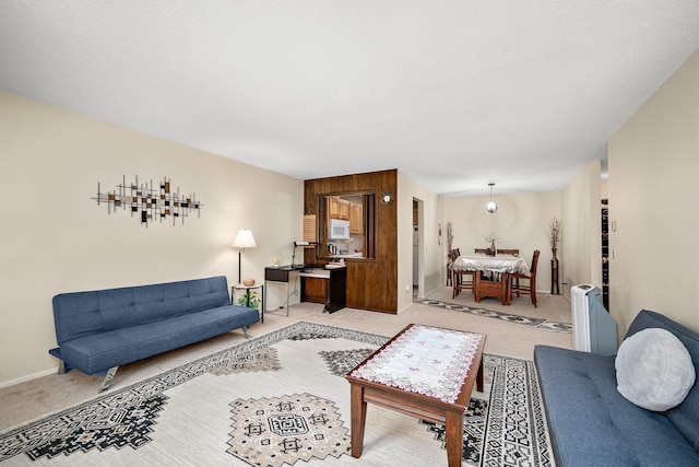 carpeted living area featuring baseboards