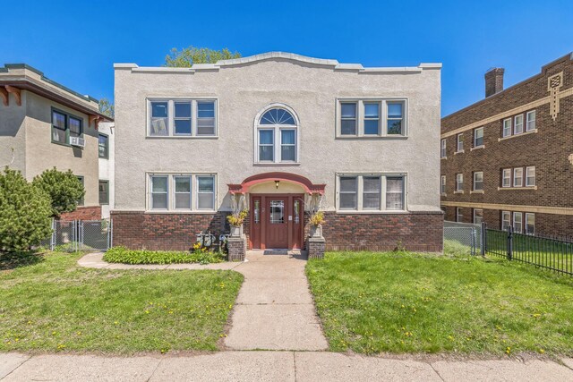 view of front facade featuring stucco siding, a gate, and brick siding