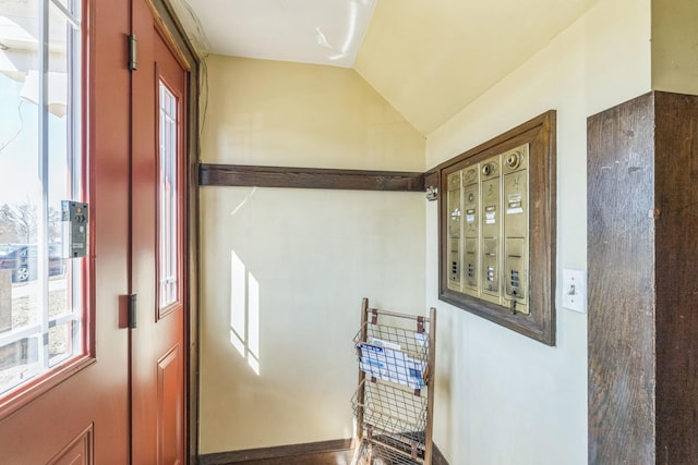 doorway to outside featuring plenty of natural light and lofted ceiling