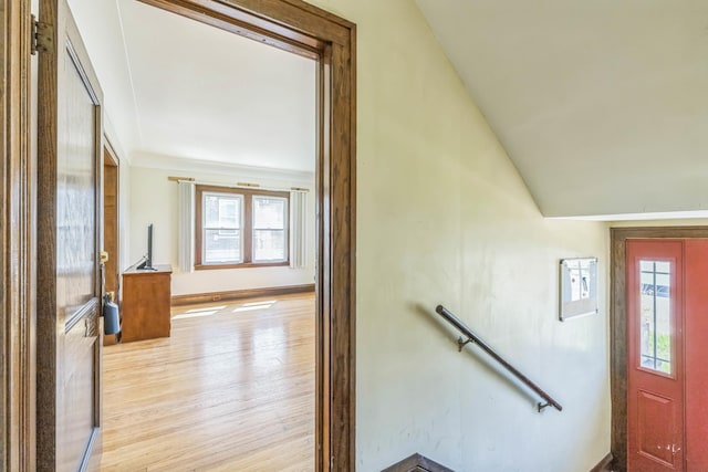 foyer entrance with wood finished floors, baseboards, and lofted ceiling