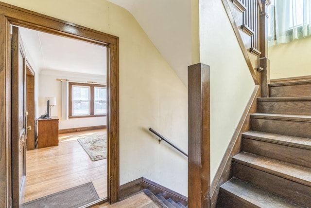 stairs featuring wood finished floors, vaulted ceiling, and baseboards