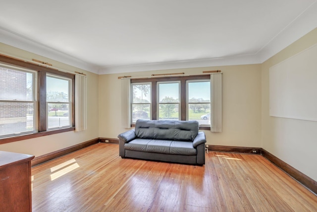 living area featuring plenty of natural light, light wood-style flooring, and baseboards