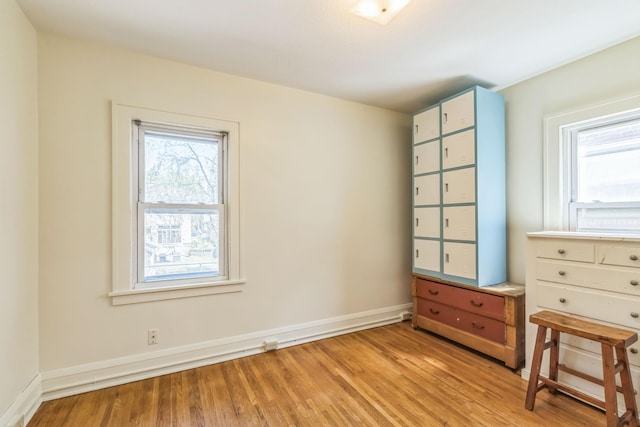 spare room with plenty of natural light, light wood-style flooring, and baseboards