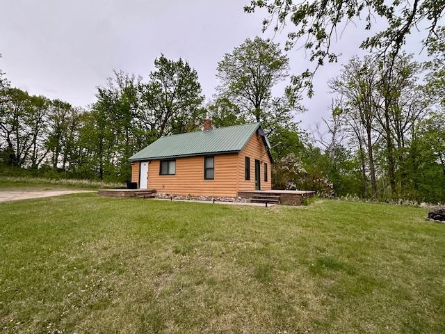 12787 Lumberjack Rd NW, Shevlin, MN 56676 - view of side of home with a yard, a chimney, and metal roof