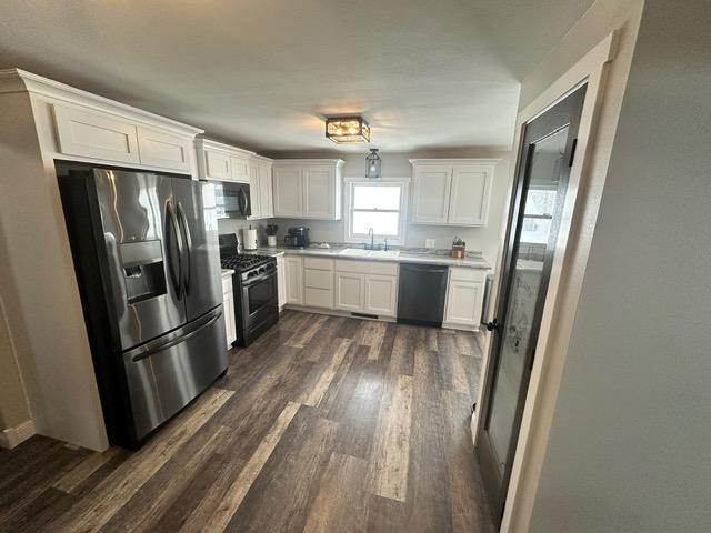 12787 Lumberjack Rd NW, Shevlin, MN 56676 - kitchen featuring black appliances, a sink, dark wood-style floors, white cabinetry, and light countertops