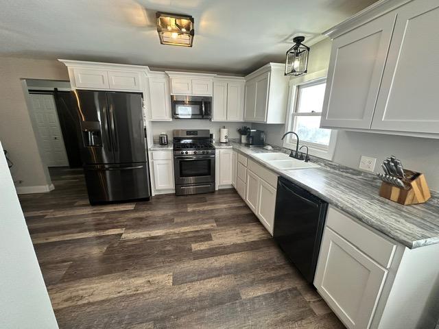 12787 Lumberjack Rd NW, Shevlin, MN 56676 - kitchen featuring black appliances, a sink, dark wood-type flooring, and white cabinetry