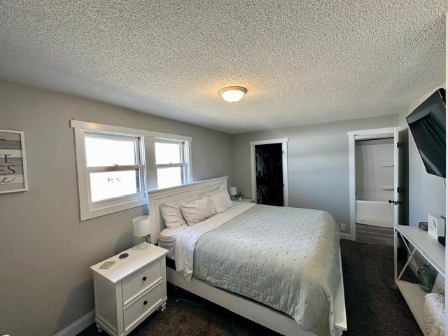 12787 Lumberjack Rd NW, Shevlin, MN 56676 - bedroom featuring a textured ceiling, dark colored carpet, and baseboards