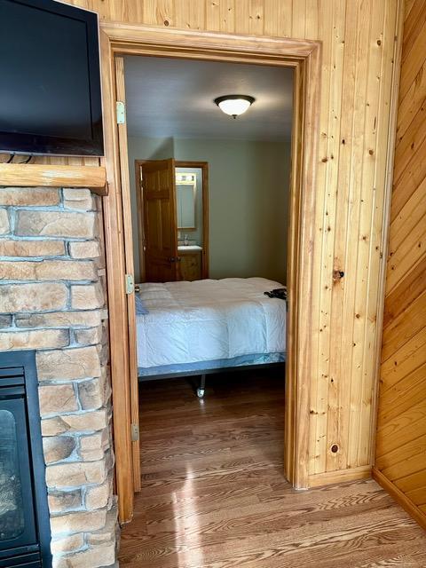 12787 Lumberjack Rd NW, Shevlin, MN 56676 - unfurnished bedroom featuring wood finished floors, wood walls, and ensuite bathroom