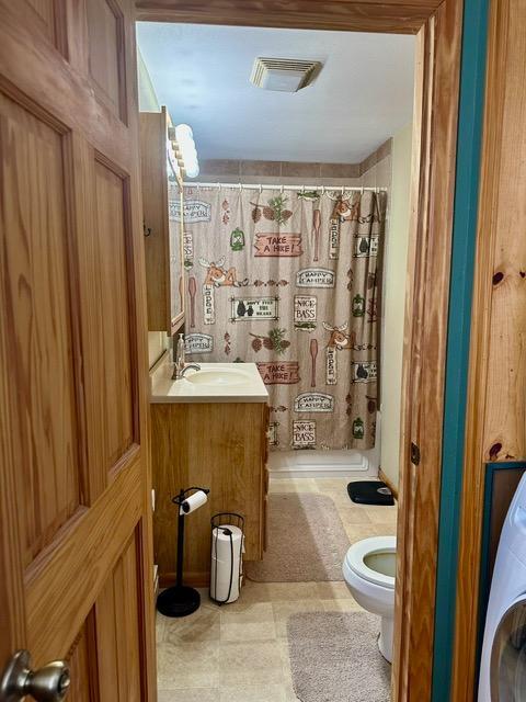 12787 Lumberjack Rd NW, Shevlin, MN 56676 - full bathroom with washer / dryer, toilet, a shower with shower curtain, and vanity