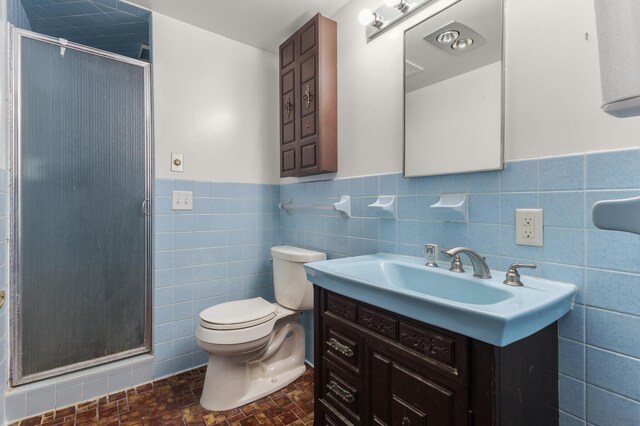 3301 Yosemite Ave S, Saint Louis Park, MN 55416 - bathroom with a stall shower, tile walls, vanity, wainscoting, and toilet