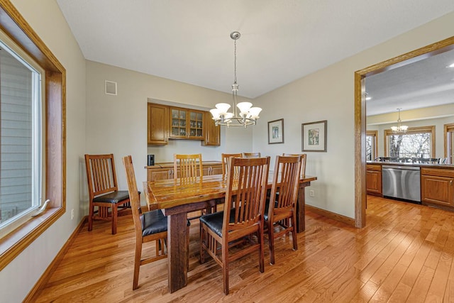 567 Forest Ln, Medford, MN 55049 - dining space featuring light wood-type flooring, visible vents, baseboards, and a notable chandelier