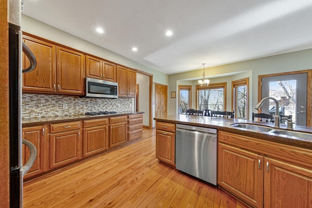 567 Forest Ln, Medford, MN 55049 - kitchen with a sink, light wood-style floors, brown cabinetry, decorative light fixtures, and appliances with stainless steel finishes