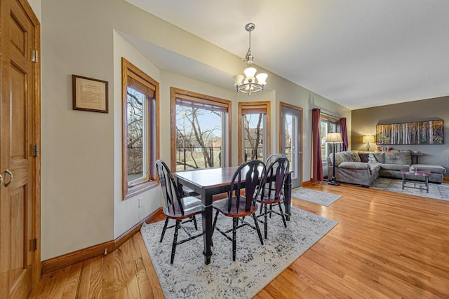 567 Forest Ln, Medford, MN 55049 - dining room with light wood-type flooring, baseboards, and a notable chandelier