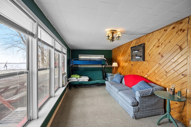 carpeted bedroom featuring wooden walls
