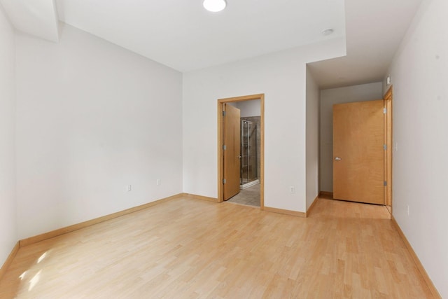 3707 Grand Way Unit 101, Saint Louis Park, MN 55416 - unfurnished bedroom featuring light wood-style floors, baseboards, and connected bathroom