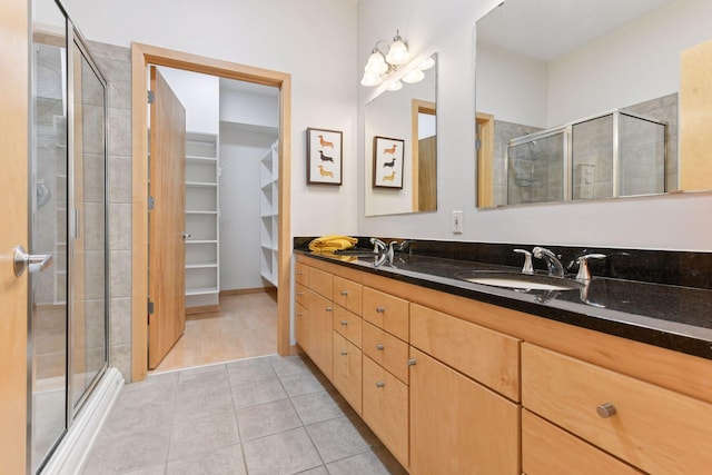 3707 Grand Way Unit 101, Saint Louis Park, MN 55416 - full bathroom with a stall shower, double vanity, tile patterned floors, and a spacious closet