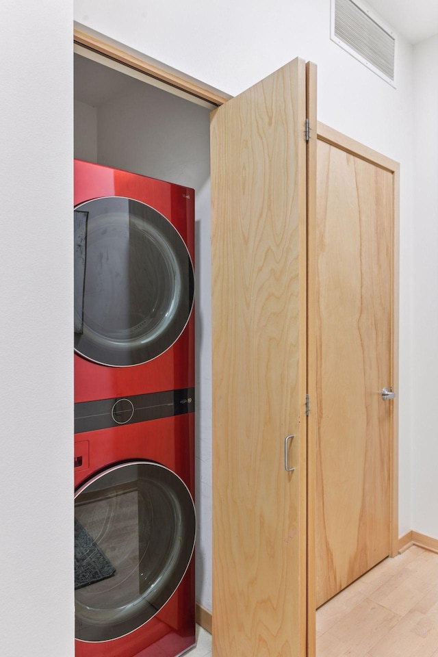 3707 Grand Way Unit 101, Saint Louis Park, MN 55416 - washroom featuring stacked washing machine and dryer and wood finished floors