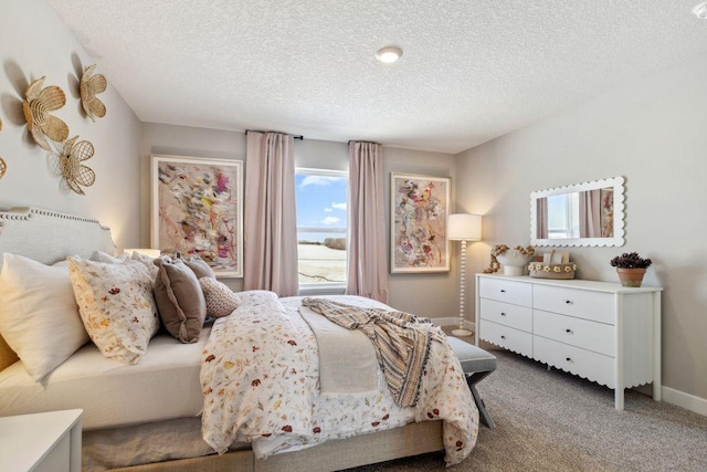 bedroom with baseboards, a textured ceiling, and carpet