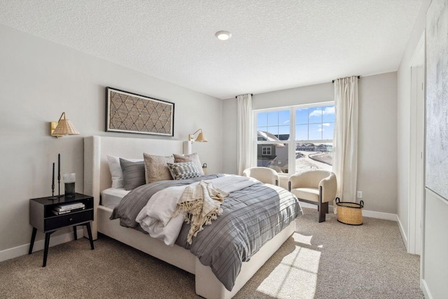 carpeted bedroom with a textured ceiling and baseboards